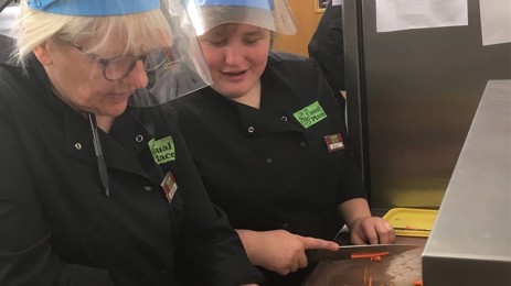 Workers cutting food in the kitchen at the Usual Place