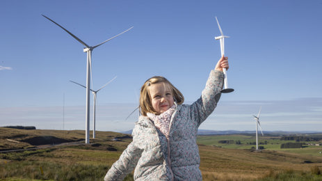 Girl in front of wind turbine