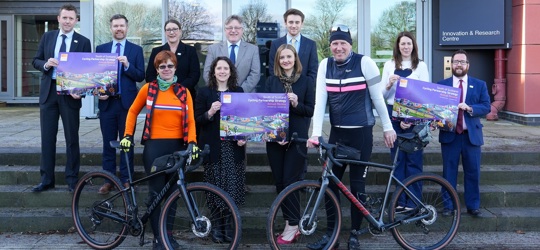 Group of key representatives holding up Cycling partnership annual report