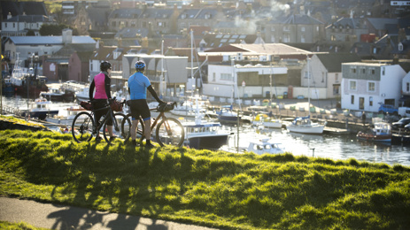 Two cyclists overlooking harbour